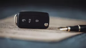 Keys, on a contract with a pen to sign to signify the article titled rent to buy cars